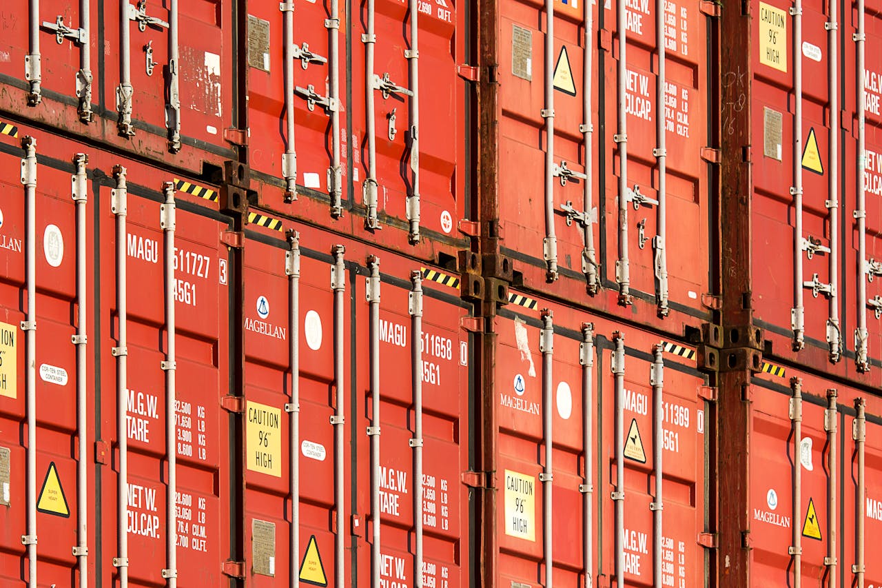 Services Close-up of stacked red shipping containers used for logistics and global trade.